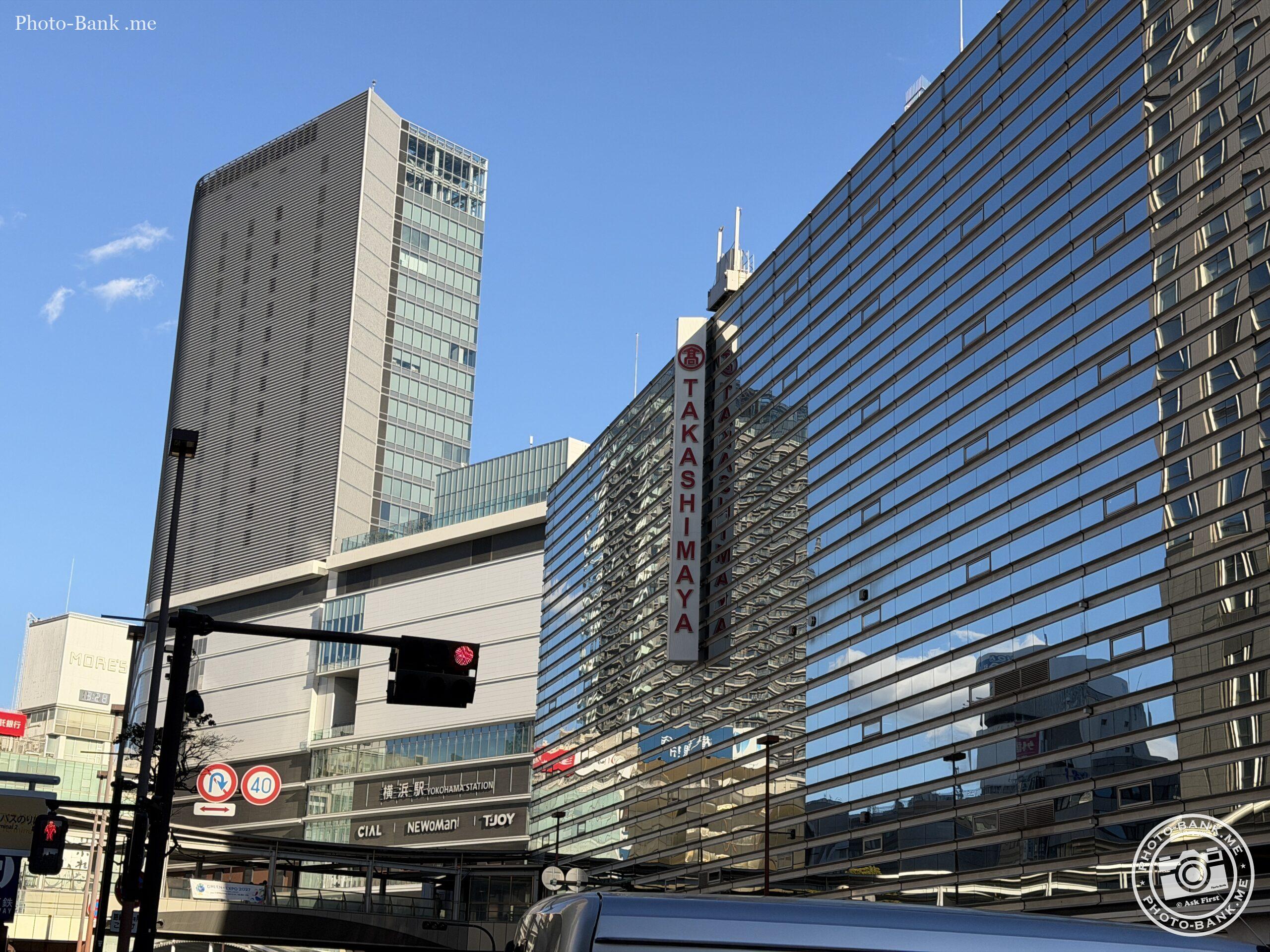横浜駅西口の高島屋と周辺の駅ビル群。冬晴れの空がビルのガラスに反射。