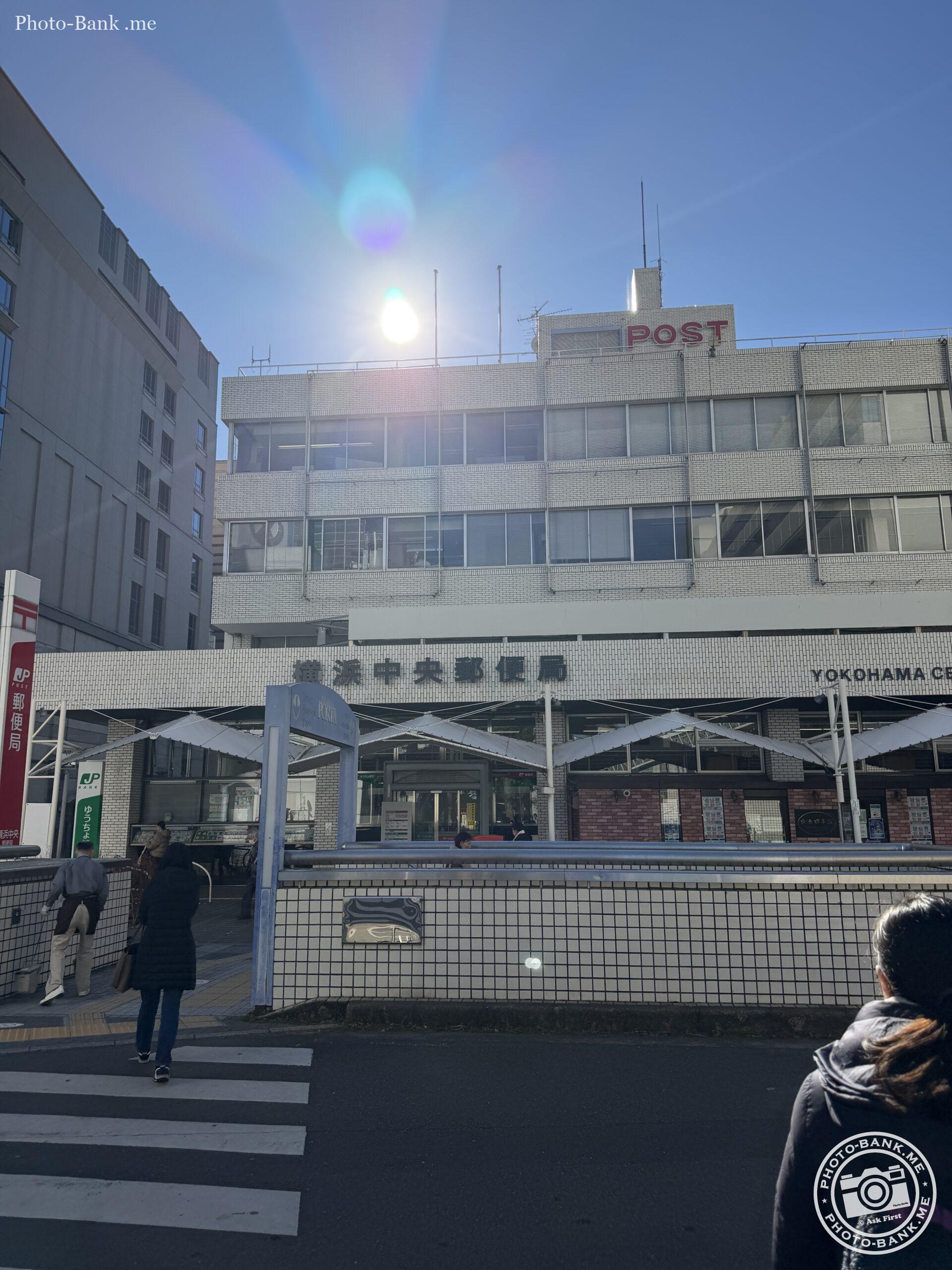 横浜中央郵便局、白い煉瓦造りの建物に赤い「POST」の文字。再開発の噂がある街角の風景。