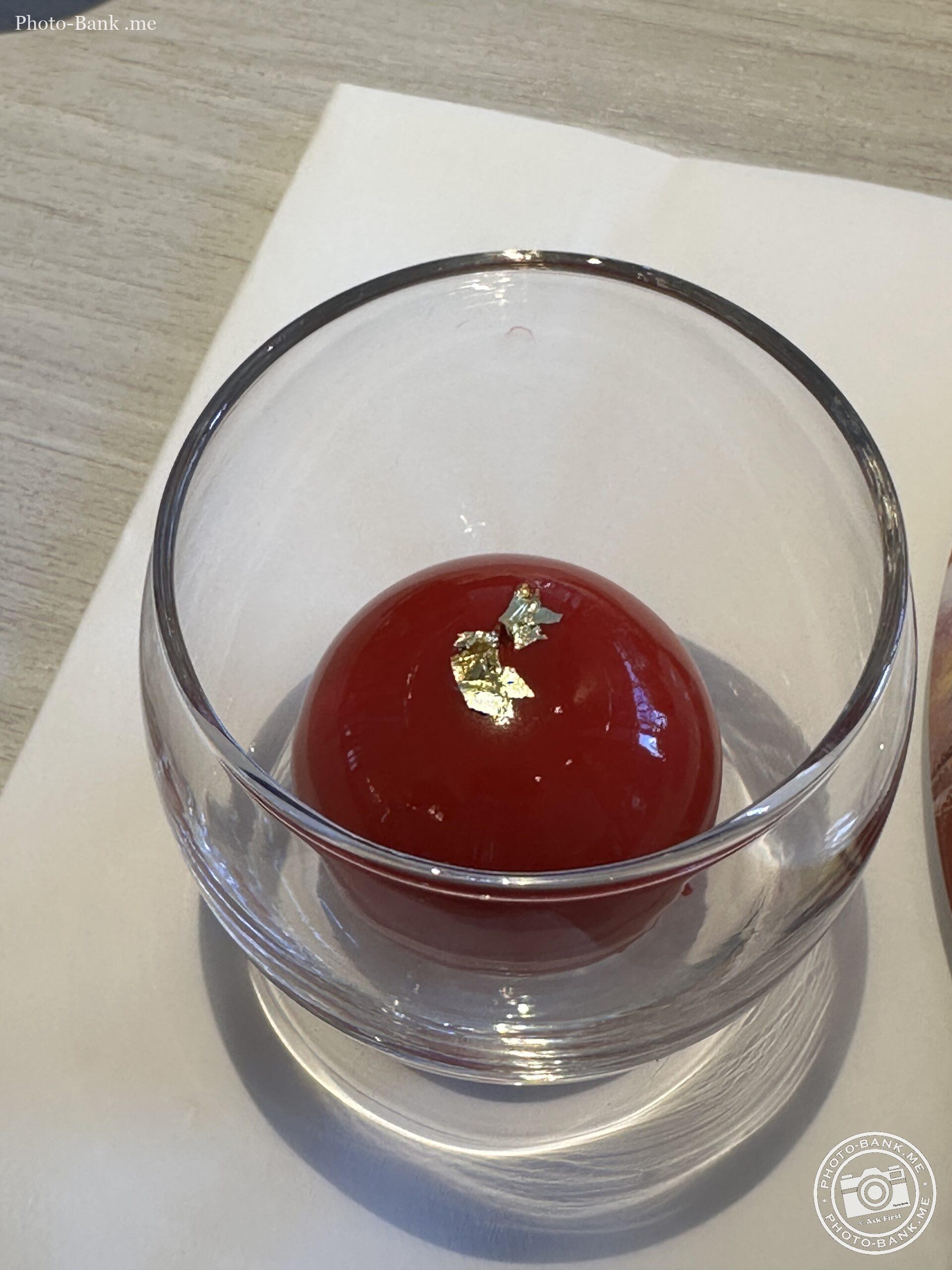 ヒルトン横浜 ALLDAY PARADE DININGで撮影された、金箔が飾られた赤い球体のデザート、ルージュ・スフィア。