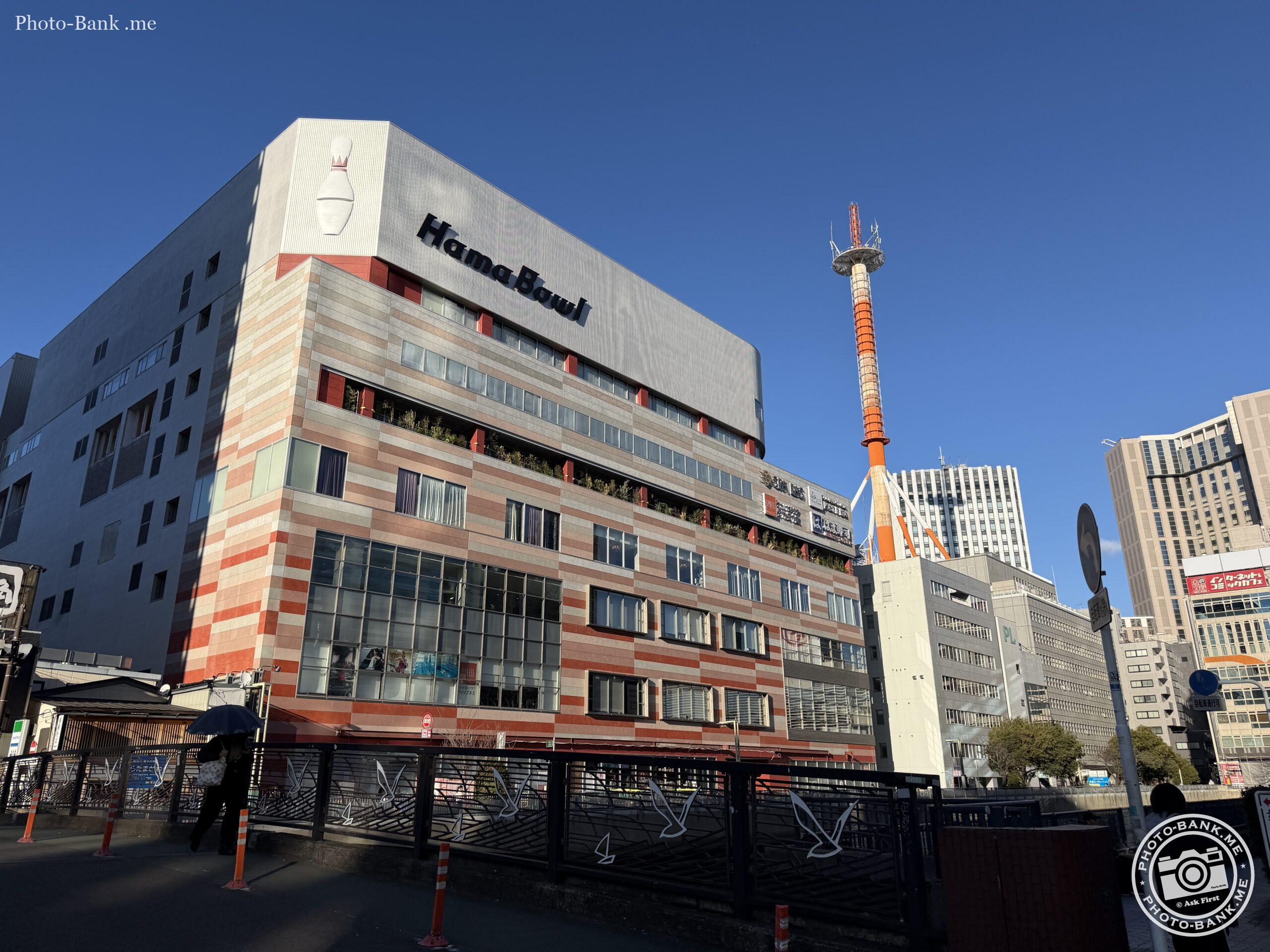 横浜駅西口に建つハマボールの建物と、特徴的な赤白のタワーが青空に映える写真