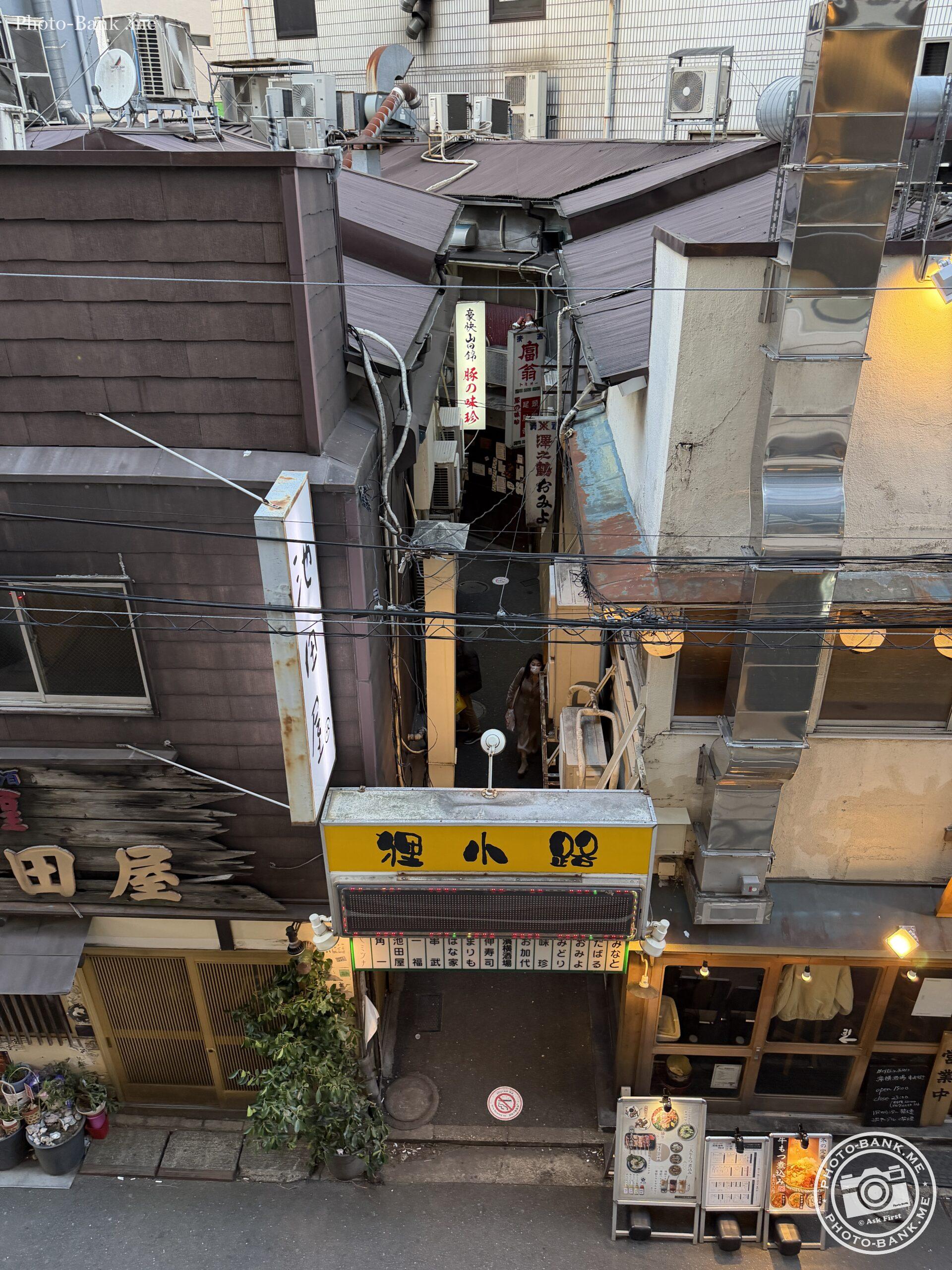 狸小路の夜景、複雑な配管、飲食店の看板、エアコン室外機が密集