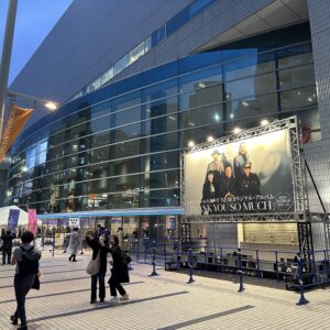 横浜アリーナに設置されたサザンオールスターズのアルバム広告、撮影者や通行人