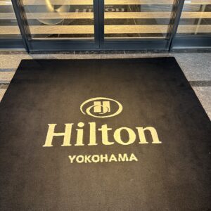 横浜ヒルトンホテルのエントランスに敷かれたロゴ入り絨毯。