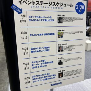 CP+2025のタムロンブースに掲示されたイベントステージのスケジュール表。
