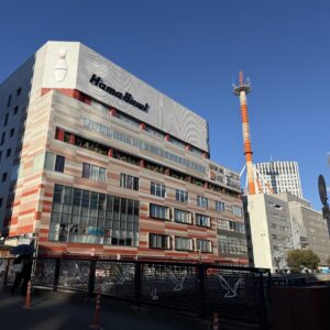 横浜駅西口に建つハマボールの建物と、特徴的な赤白のタワーが青空に映える写真