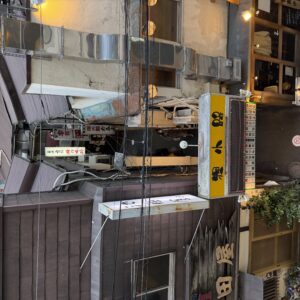 狸小路の夜景、複雑な配管、飲食店の看板、エアコン室外機が密集