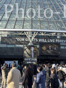 東京ドームのガラス張りの壁面とライスボウルの広告、そして観戦を待つ人々